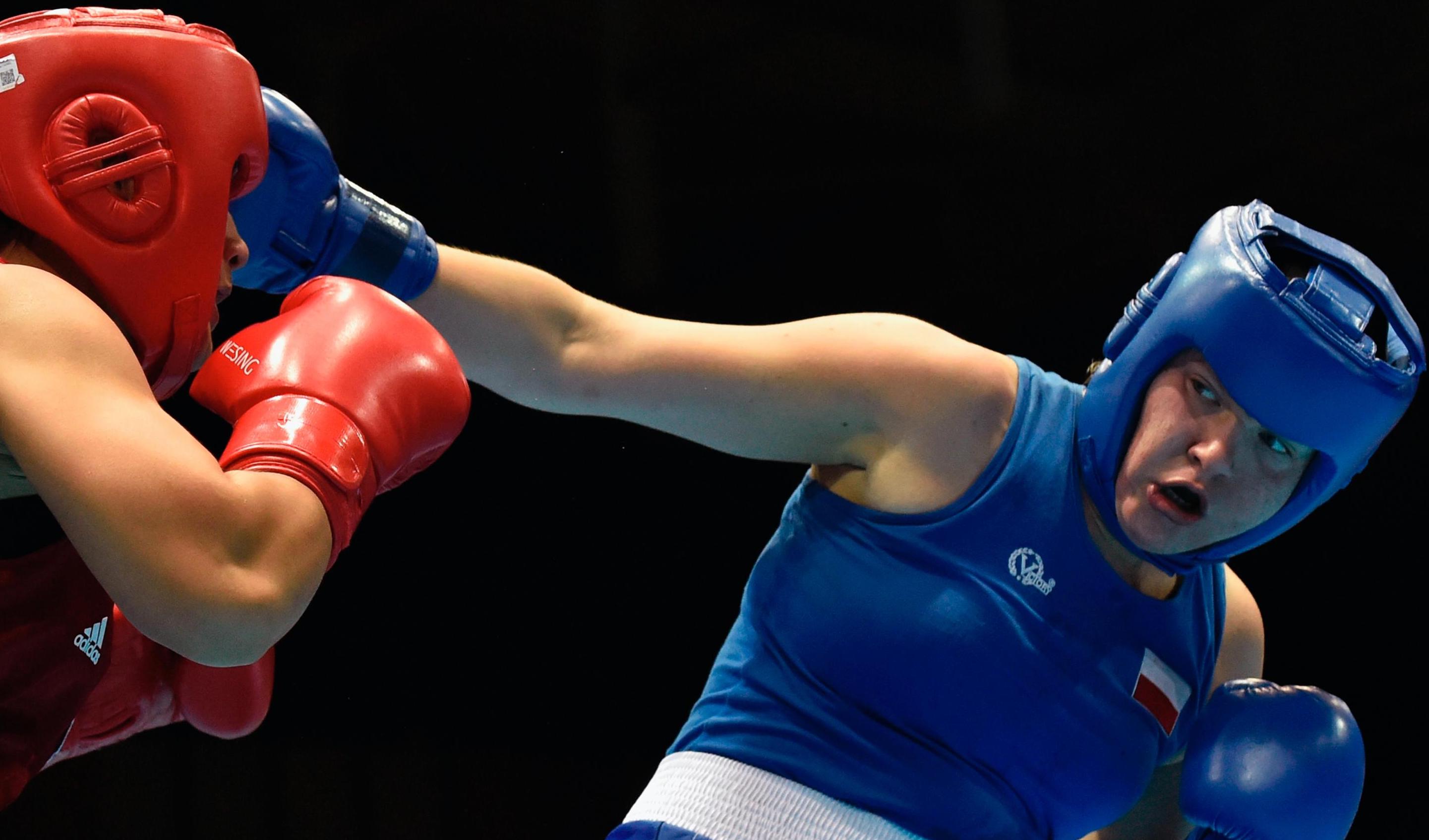 Two boxers in a match. One of the boxers hitting the other boxer in the head