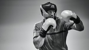 Photo in black and white of a boxer with gloves and his hands in a fighting position