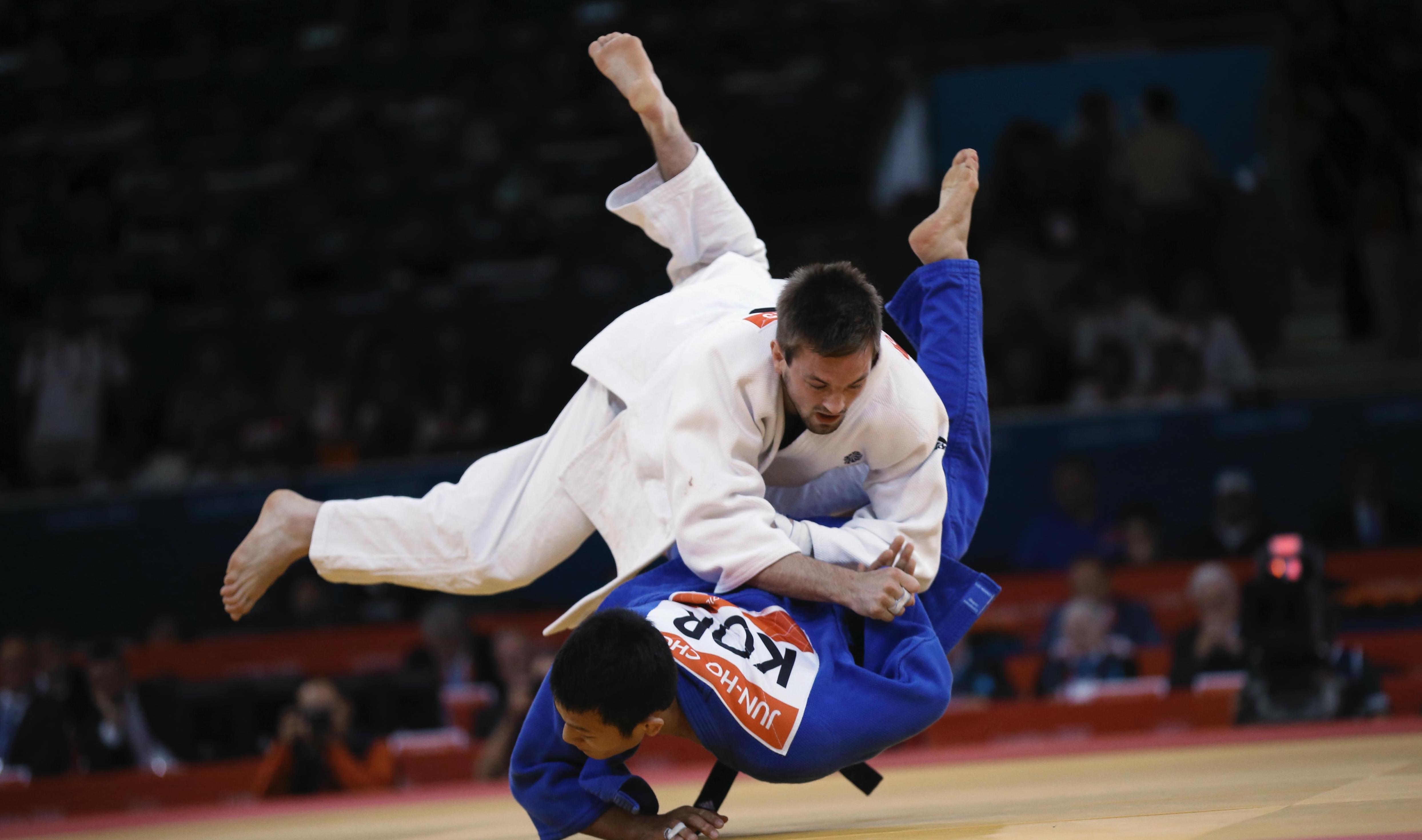 Two Judo athletes in a match, one athlete has thrown the other into the ground